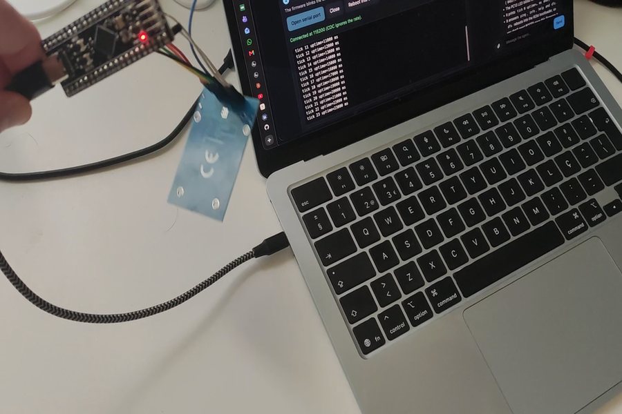 The Black Pill flashed and running, its serial console open on the laptop